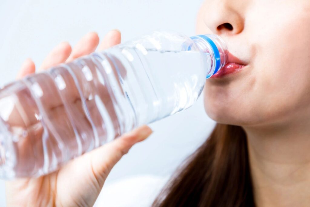 Woman drinking cold water for hydration and fat loss